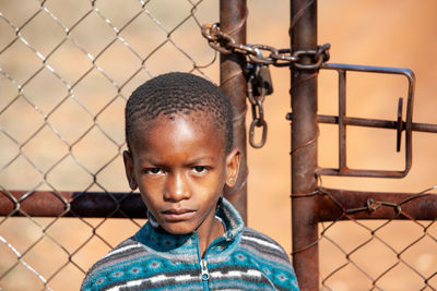 Portrait of boy with metal fence
