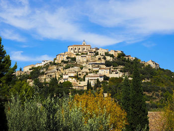 Low angle view of buildings on mountain against sky