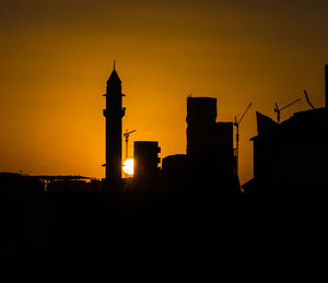 Silhouette city against sky during sunset