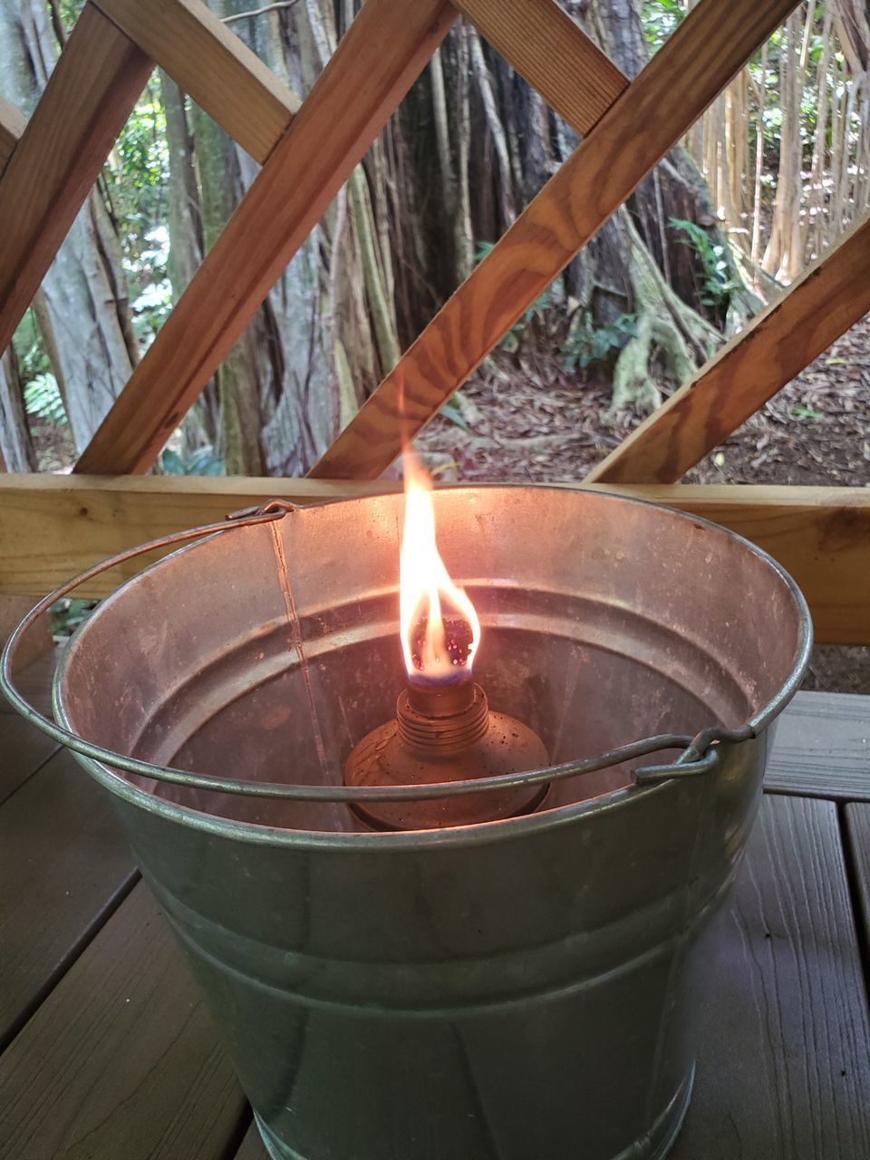 CLOSE-UP OF BURNING CANDLE IN METAL CONTAINER