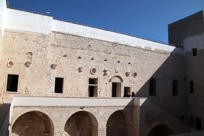 Low angle view of old building against clear blue sky