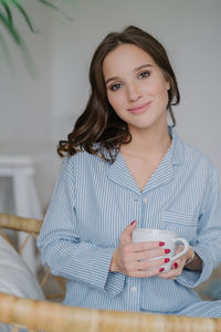 Portrait of a beautiful young woman drinking glasses