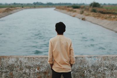 Rear view of man looking at river 