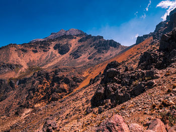 Scenic view of mountains against blue sky