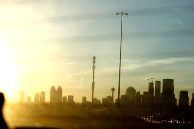 Modern buildings in city against sky during sunset