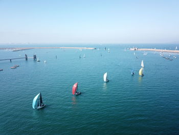 Sailboats in sea against sky