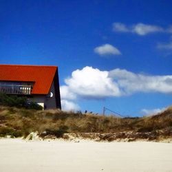 Houses on landscape against blue sky