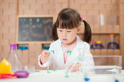 Young girl playing science experiment at home