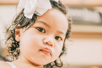 Close-up portrait of cute girl at home