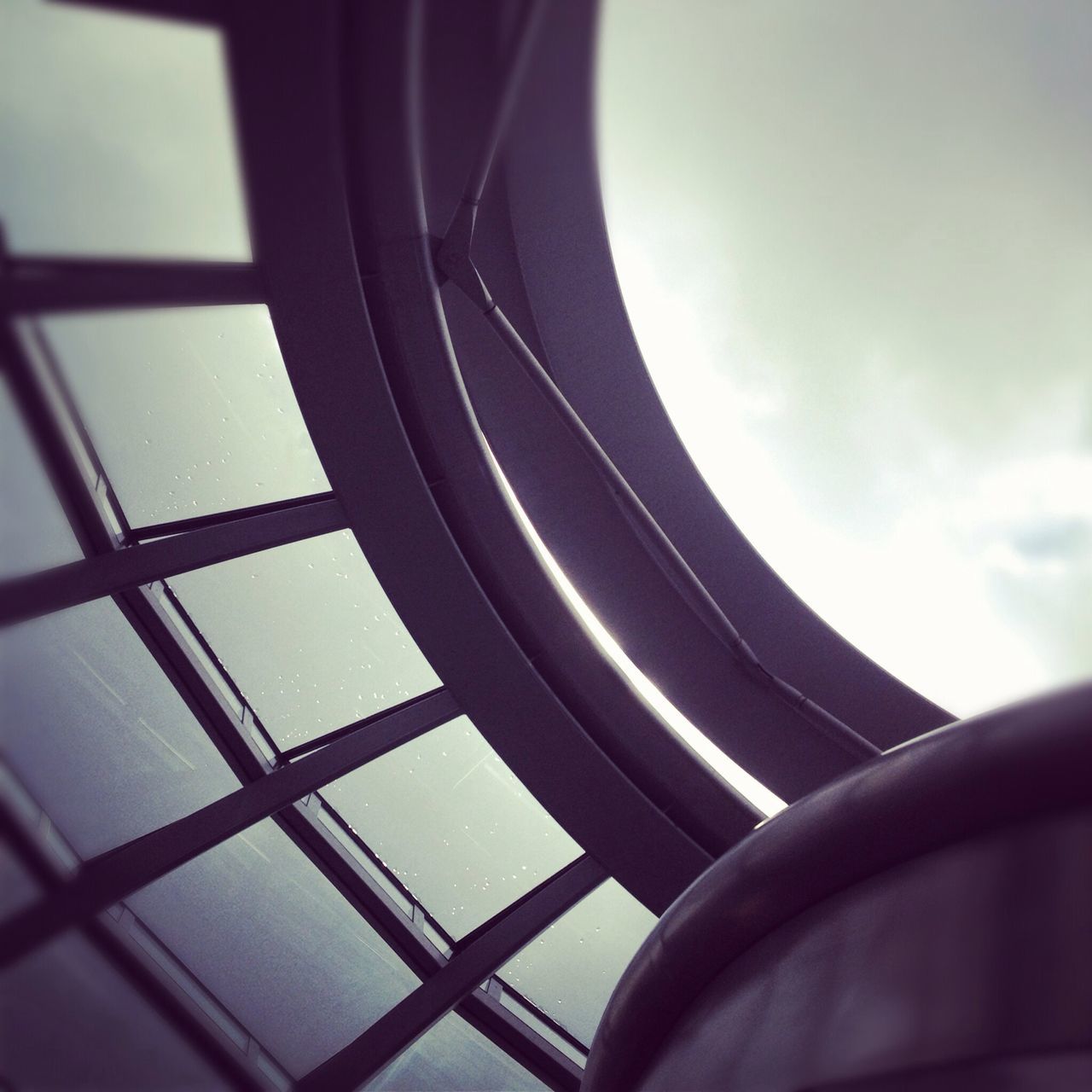 indoors, low angle view, window, sky, geometric shape, part of, close-up, built structure, cropped, glass - material, no people, pattern, architecture, transparent, modern, day, railing, shape, circle, directly below