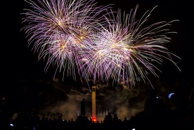 Low angle view of firework display at night