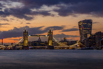 View of illuminated bridge over river against cloudy sky