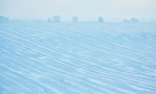 Scenic view of snow covered field against sky