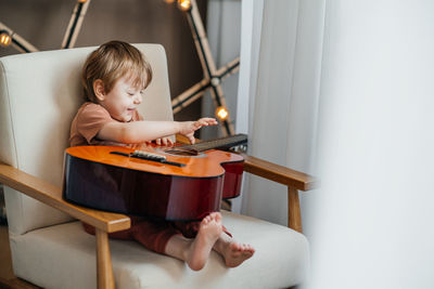 Little boy playing classical guitar. high quality photo