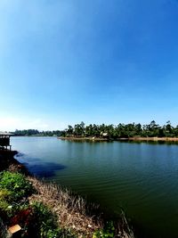 Scenic view of lake against clear blue sky