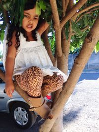 Full length of girl sitting on tree