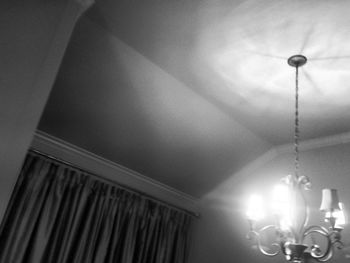 Illuminated chandelier hanging on ceiling