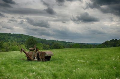 Scenic view of grassy field against cloudy sky