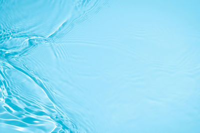 Transparent blue colored clear calm water surface texture