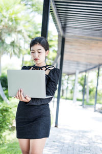 Beautiful businesswoman in black working on laptop . comfortable work or remote work concept.