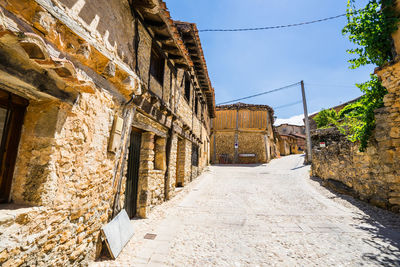 Footpath amidst buildings against sky