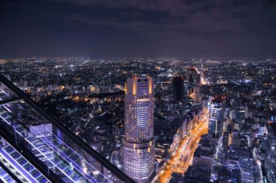 Aerial view of illuminated buildings in city at night