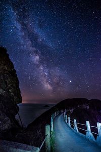 Scenic view of bridge over mountain against sky at night