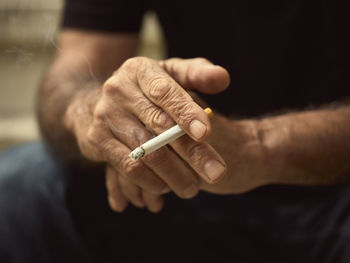 Close-up of hand holding cigarette