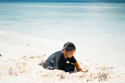 Cute girl playing on sand at beach