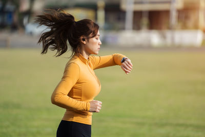 Portrait of young woman exercising in park