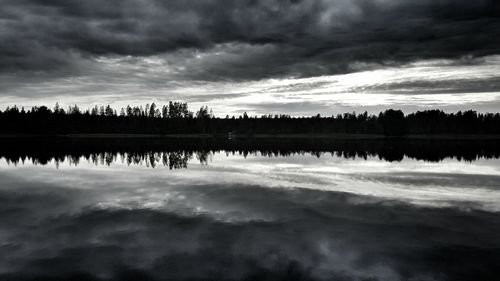 Scenic view of calm lake against cloudy sky