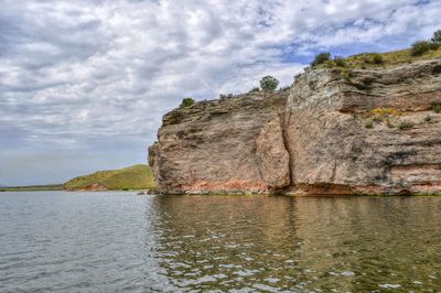 Rock formations by sea against sky