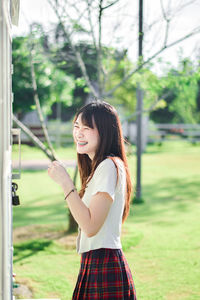 Young woman standing against trees