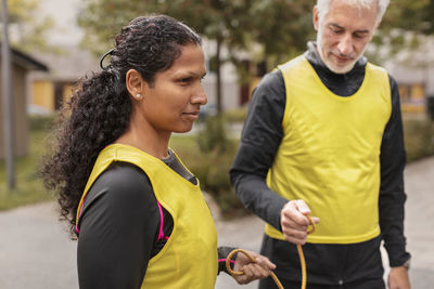 Visually impaired woman preparing for jogging with guide runner