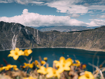 Scenic view of lake by mountains against sky