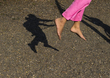 Low section of woman with shadow on street