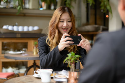 Young woman using mobile phone at restaurant