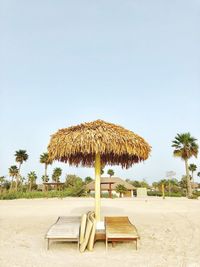 Chair on beach against clear sky