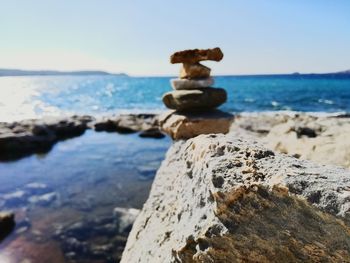 Close-up of rocks on beach against sky