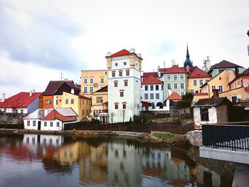 Buildings in town against cloudy sky