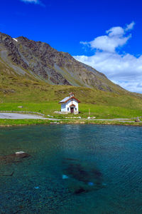 Scenic view of building and mountains against blue sky