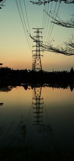 Silhouette electricity pylon by lake against sky during sunset