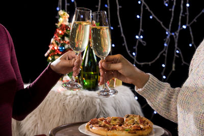 Midsection of woman toasting champagne flutes 