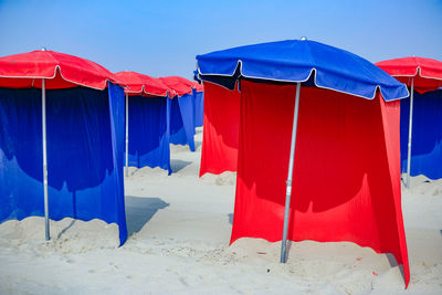 Multi colored umbrellas on beach against clear blue sky