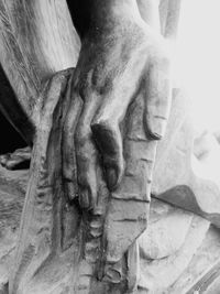 Close-up of human hand against statue