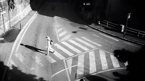 High angle view of man walking on zebra crossing