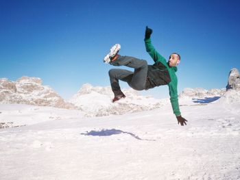 Full length of man on snowcapped mountain against sky