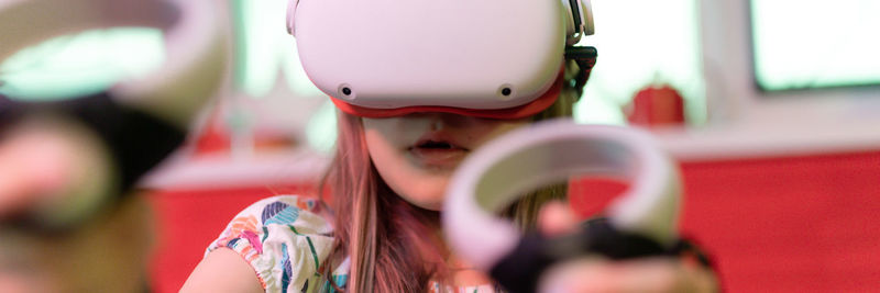 Vr game and virtual reality. kid girl gamer fun playing on futuristic simulation video shooting game