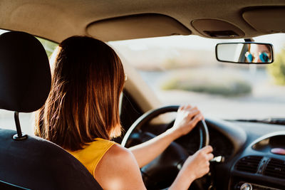 Side view of woman sitting in car