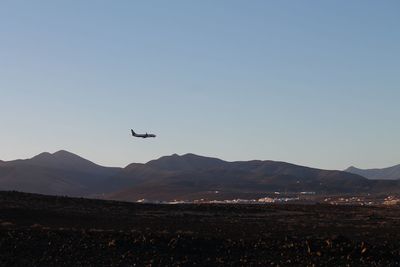 Low angle view of airplane flying above mountains